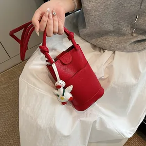 Chic red lychee grain leather mini bucket bag with a cute white duck charm for women