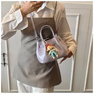 Detail of lavender pleated bucket bag with metallic buckle and cute character charm