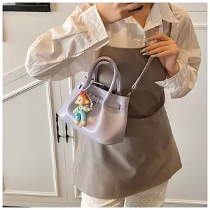 Detail of lilac bucket bag with glossy PU leather, metal buckle and clown charm