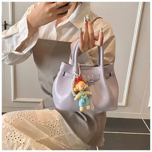 Detail of lavender pleated bucket bag featuring metallic buckle and cartoon doll pendant