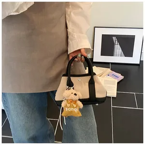 Mini beige canvas tote with black leather trim and cute teddy bear charm detail