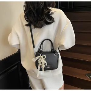 Sac seau noir élégant avec breloque en perles et dentelle porté en bandoulière
