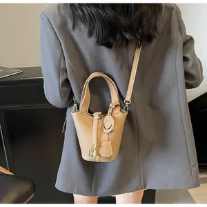 Detail view of khaki PU leather bucket bag with gold padlock and detachable shoulder strap