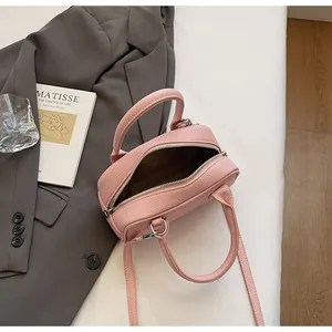 Vista dettagliata della borsa in pelle martellata rosa con vano interno e manici
