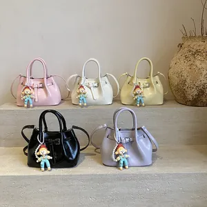 Glossy bucket bags in five colors with cute doll charms and adjustable straps