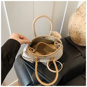Internal detail of a beige canvas tote bag with brown trim and secure zipper pocket