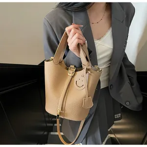 Close-up of camel bucket bag with lychee grain leather and smiling face detail