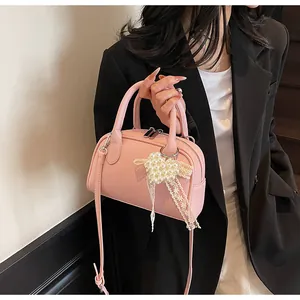 Borsa a tracolla rosa texture litchi con ciondolo a cuore di perle e dettaglio in pizzo