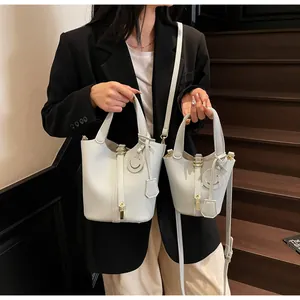 Detail view of white lychee pattern bucket bags with gold locks and smiley charms