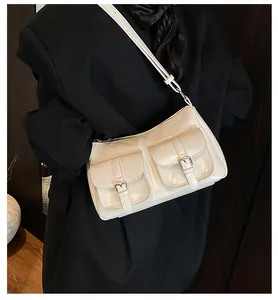 Detail of a creamy white PU leather tote with metallic buckles and vintage pockets