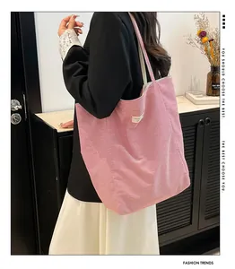 Détail d'un sac cabas en toile à rayures roses et blanches avec larges bandoulières