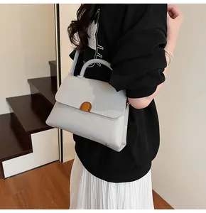 Détail d'un sac à main gris clair en cuir grainé avec fermoir vintage en métal doré