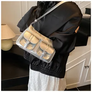 Detail of silver metallic Y2K shoulder bag with dual functional flap pockets and buckles