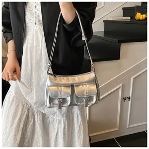 Detail of silver metallic tote bag with double utility buckle pockets and adjustable strap