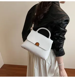 Détail du sac à main blanc motif litchi avec fermoir doré élégant et bandoulière réglable