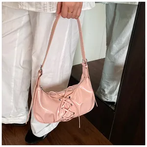Detailed view of pink glossy patent leather shoulder bag featuring corset lace-up design