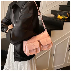 Pink patent leather tote with cargo pockets and metallic buckles shown in a lifestyle setting