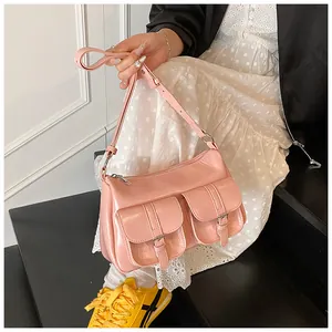 Detail of pink glossy tote bag featuring symmetric front pockets and silver buckles