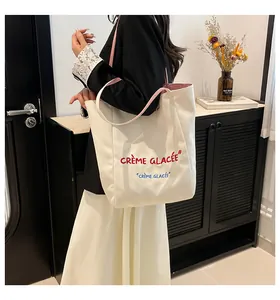 Détail du sac cabas en toile montrant l'imprimé français et la texture de l'anse rayée