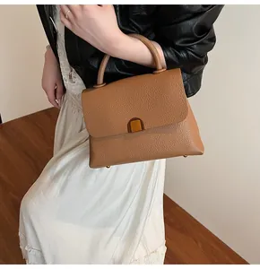 Détail du sac en cuir litchi caramel avec boucle dorée et poignée supérieure unique