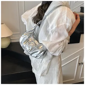 Detail of silver metallic handbag featuring decorative cross-tie ribbon and balletcore bow