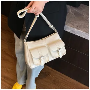 Detail of off-white faux leather tote bag with functional silver buckle pockets
