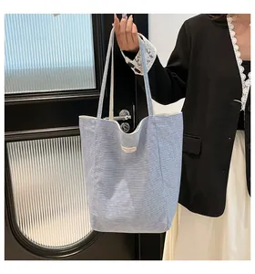 Gros plan sur un grand sac cabas en toile à rayures bleu et blanc avec étiquette brodée