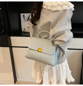 Vue détaillée du sac à main bleu clair en cuir grainé avec fermoir en métal doré