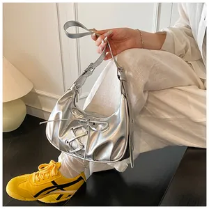 Detail of silver metallic hobo bag featuring lace-up bow and smooth synthetic leather