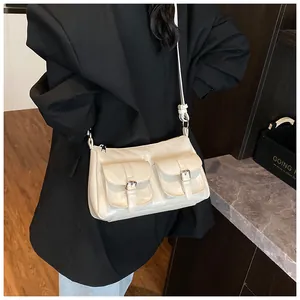 Detail showing creamy white soft leather crossbody bag with metal buckle pockets