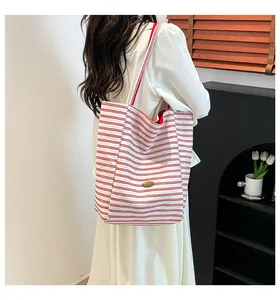 Détail du grand sac cabas en toile à rayures rouges et blanches avec plaque métallique