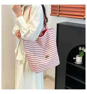 Détail macro du sac fourre-tout en toile à rayures rouges et blanches avec logo