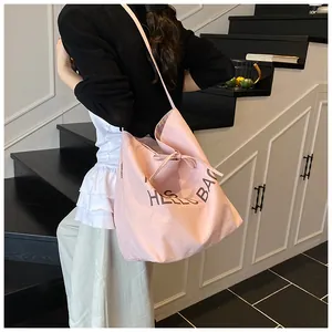 Detail of light pink canvas tote bag featuring Hello Bag print and drawstring closure
