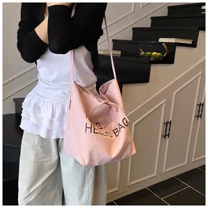Close-up of pink canvas tote featuring bow drawstring detail and Hello Bag lettering