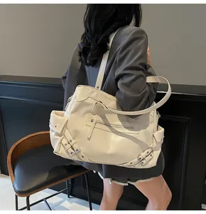 Detail of cream large tote bag with glossy faux leather and vintage rivet accents