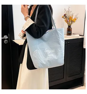 Sac fourre-tout en toile bleu clair avec imprimé beyou merci et bandoulière rayée sur mannequin