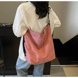 Detail of dusty rose canvas tote bag with adjustable black wide strap on model back