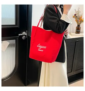 Vue détaillée du sac cabas en toile rouge avec broderie Beyou Merci blanche et grand volume
