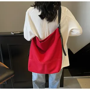 Rear view of vibrant red canvas hobo bag with reinforced stitching and adjustable strap