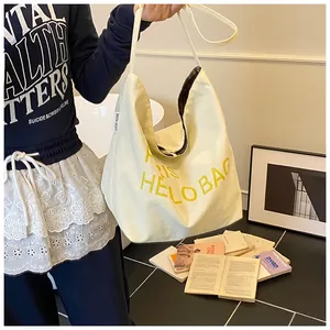 Detail of canvas tote bag with yellow letters, plaid lining and lucky home label