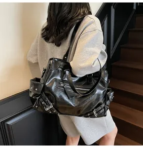 Close-up of black retro rivet tote bag with glossy finish and functional zipper detail