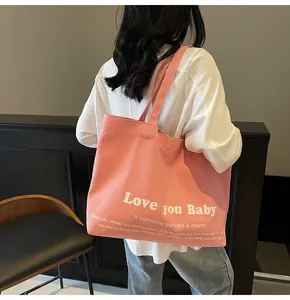 Detail of pink canvas tote bag with Love you Baby slogan and comfortable shoulder straps