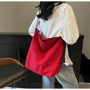 Minimalist red canvas tote bag with black wide straps shown on model for daily commute