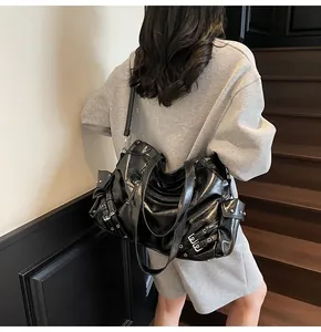 Detailed view of a vintage black glossy tote bag worn by a model on a shoulder strap