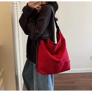 Detail of red canvas tote bag with thick texture and adjustable black strap