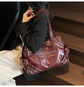 Close-up of deep burgundy vintage tote bag with retro rivet details and glossy texture