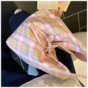 Detailed view of pink and yellow plaid canvas tote bag with decorative drawstring bow