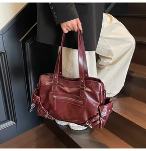 Detail of vintage red large capacity tote bag featuring glossy PU leather and side pockets