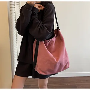 Close-up of minimalist dusty rose canvas tote bag with contrast black shoulder straps