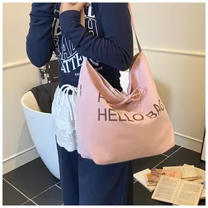Close-up of pink canvas tote bag showing Hello Bag print and rainbow striped lining